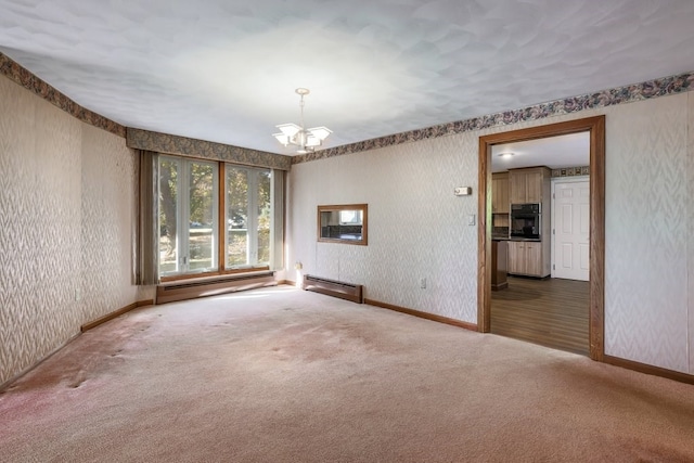 carpeted spare room with an inviting chandelier and baseboard heating