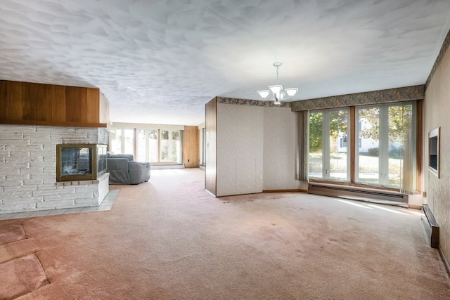 unfurnished living room with a wealth of natural light, a baseboard radiator, and light carpet