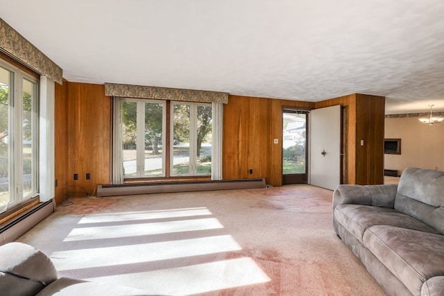 living room featuring light carpet, wood walls, a chandelier, and baseboard heating