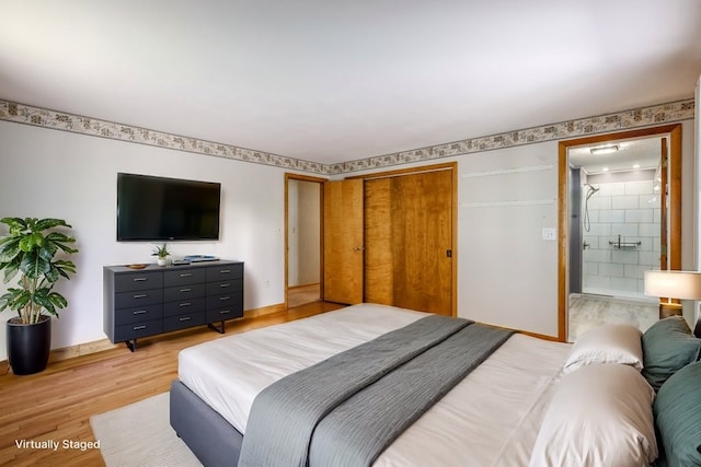 bedroom with connected bathroom, a closet, and light hardwood / wood-style floors