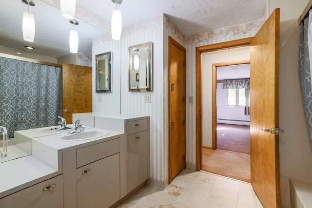 bathroom featuring baseboard heating, vanity, and a textured ceiling