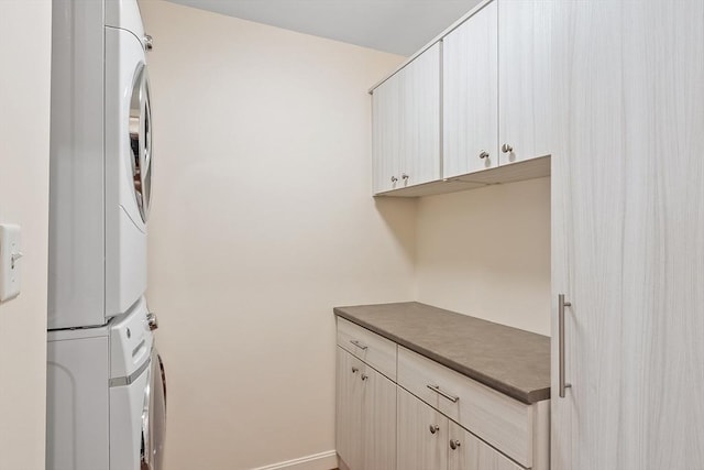 laundry room with cabinet space and stacked washing maching and dryer