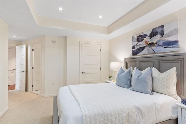 bedroom with a raised ceiling, recessed lighting, baseboards, and light carpet