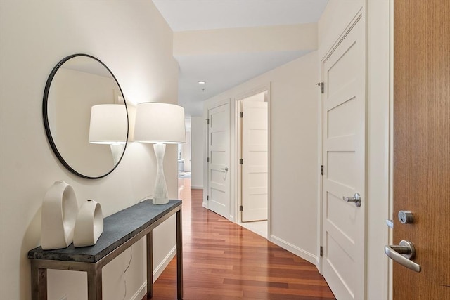 corridor featuring baseboards and wood finished floors