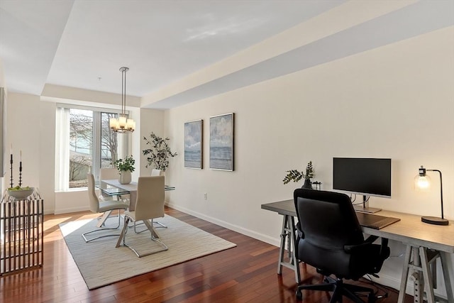 dining area with a tray ceiling, baseboards, dark wood-style flooring, and a chandelier