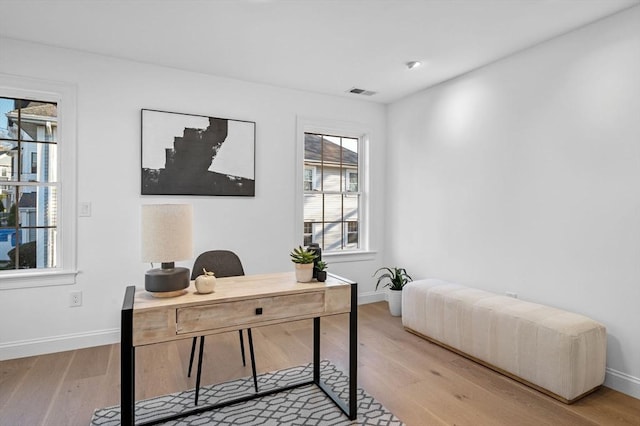 office area featuring light wood-type flooring, plenty of natural light, and baseboards