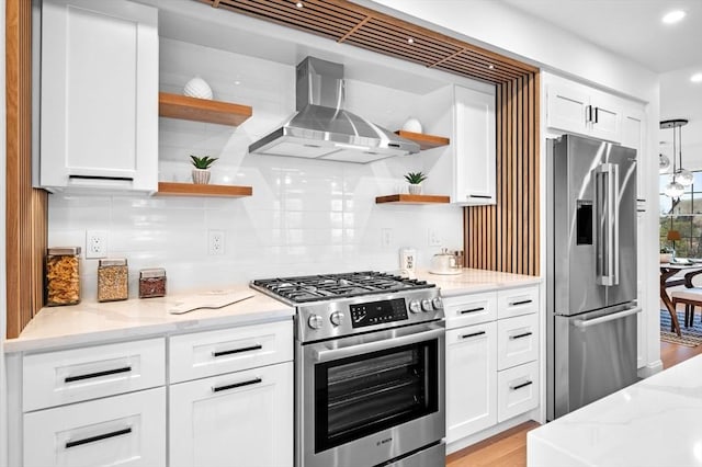 kitchen with appliances with stainless steel finishes, open shelves, wall chimney exhaust hood, white cabinetry, and decorative backsplash