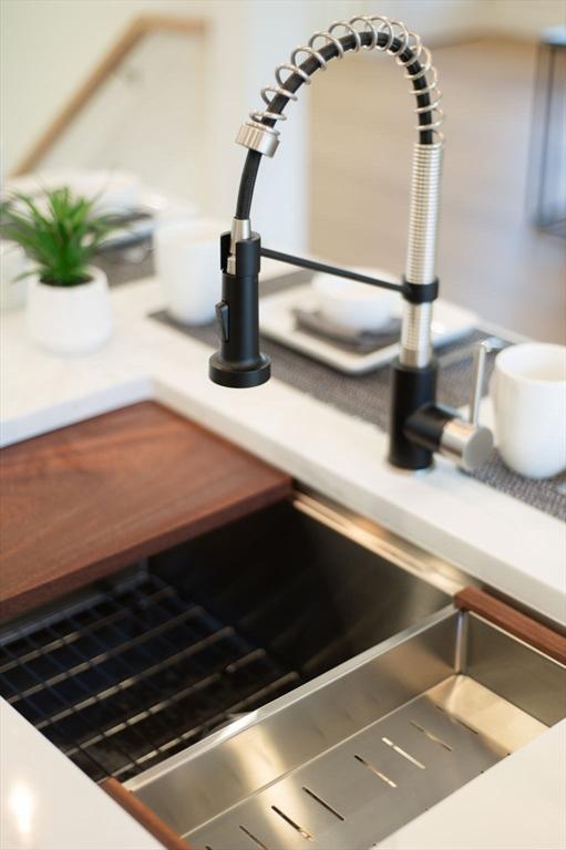 kitchen view of a sink and light countertops