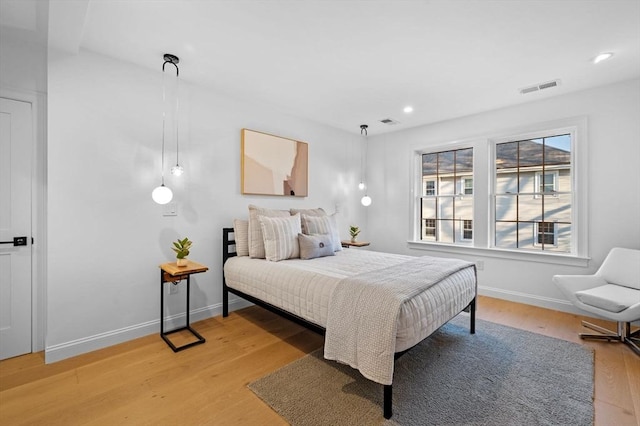 bedroom with light wood-style floors, recessed lighting, and baseboards