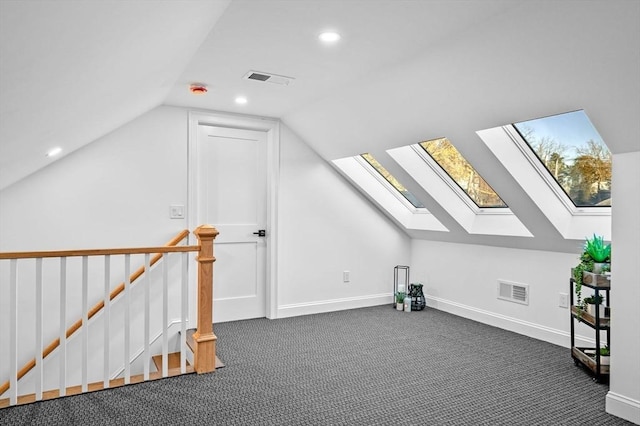bonus room featuring a skylight, lofted ceiling, dark carpet, recessed lighting, and baseboards
