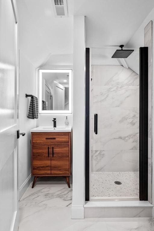 bathroom featuring a marble finish shower, vanity, and marble look tiles