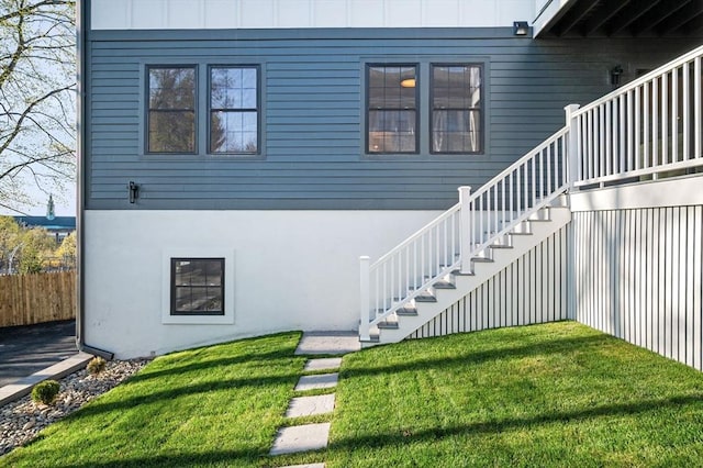 view of home's exterior featuring stairway, board and batten siding, and stucco siding