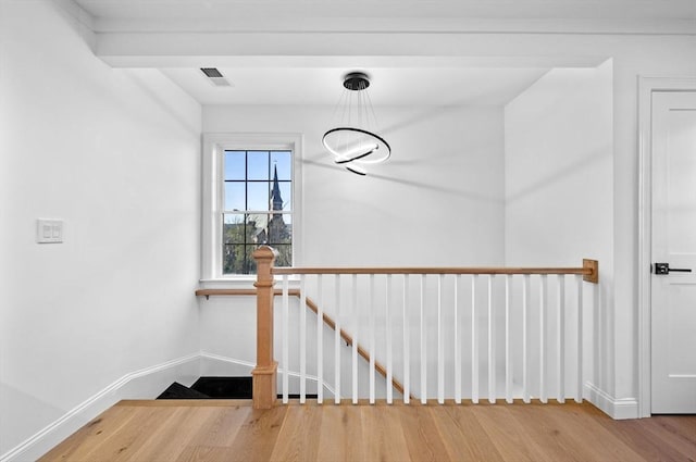 staircase featuring wood finished floors and baseboards