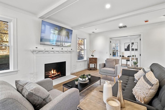 living room featuring a lit fireplace, beam ceiling, wood finished floors, and recessed lighting