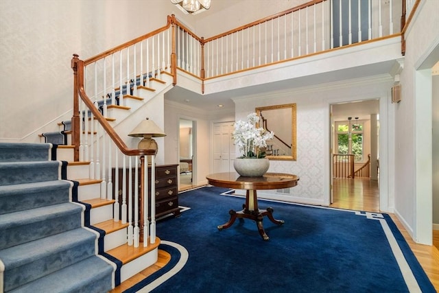8 Pleasant St, Dover, MA 02030 - stairway with a high ceiling, crown molding, baseboards, wood finished floors, and a chandelier