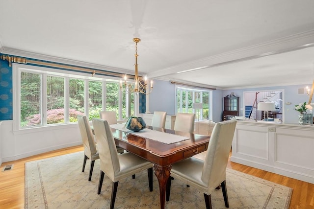 8 Pleasant St, Dover, MA 02030 - dining space with ornamental molding, a chandelier, light wood finished floors, and wainscoting