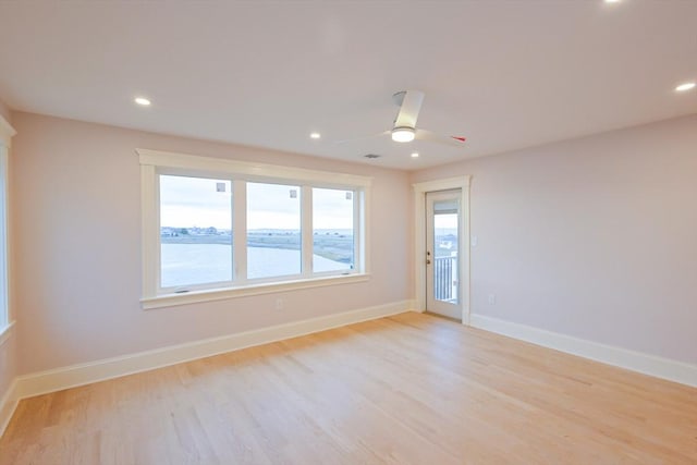 unfurnished room featuring baseboards, light wood-type flooring, and ceiling fan