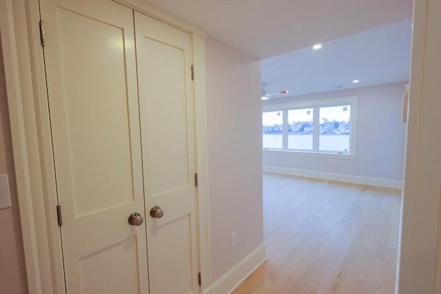 hall with baseboards, recessed lighting, and light wood-style flooring