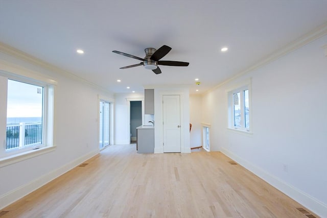 spare room with a wealth of natural light, visible vents, and ornamental molding