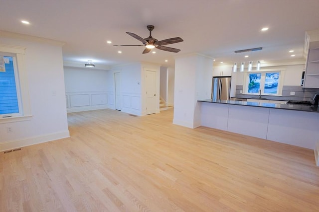 unfurnished living room with ornamental molding, recessed lighting, and light wood-style flooring