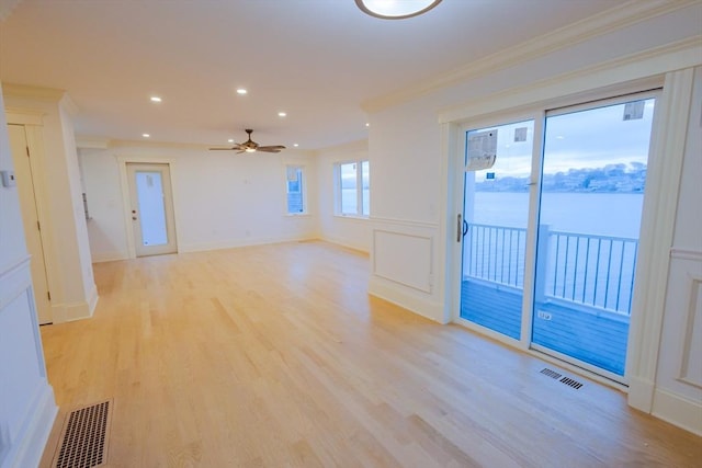 spare room with recessed lighting, light wood-style floors, ornamental molding, ceiling fan, and visible vents