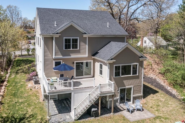 70 Rockland St, Natick, MA 01760 - back of property featuring roof with shingles, stairs, a wooden deck, a patio, and a yard
