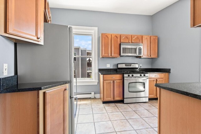 17 Savin Hill Ave Unit 3, Boston, MA 02125 - kitchen with stainless steel appliances, baseboard heating, light tile patterned floors, and dark countertops