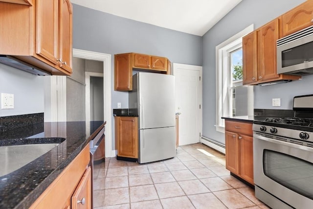 17 Savin Hill Ave Unit 3, Boston, MA 02125 - kitchen with appliances with stainless steel finishes, baseboard heating, dark stone counters, light tile patterned floors, and brown cabinets