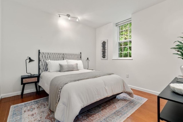 bedroom featuring wood finished floors and baseboards