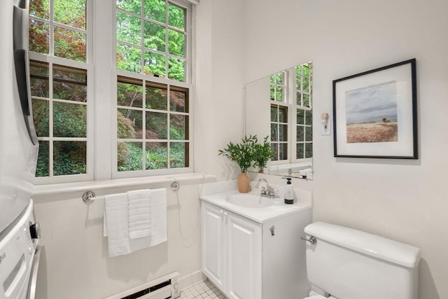 bathroom with vanity, healthy amount of natural light, toilet, and a baseboard heating unit