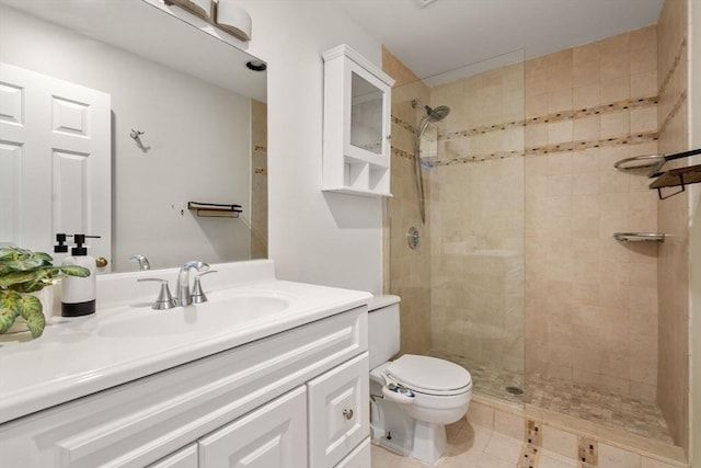 full bath with toilet, a tile shower, vanity, and tile patterned flooring