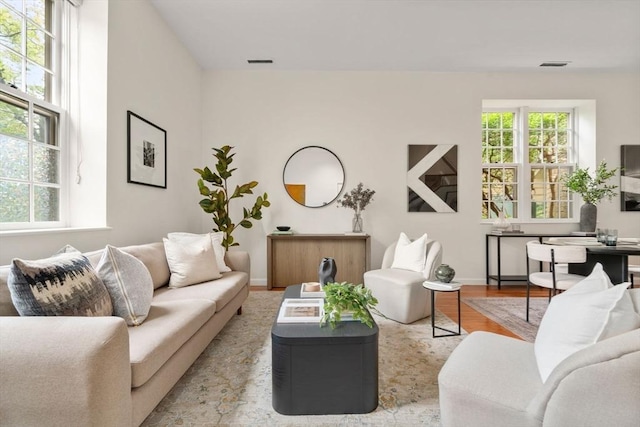 living area featuring plenty of natural light, baseboards, wood finished floors, and an office area