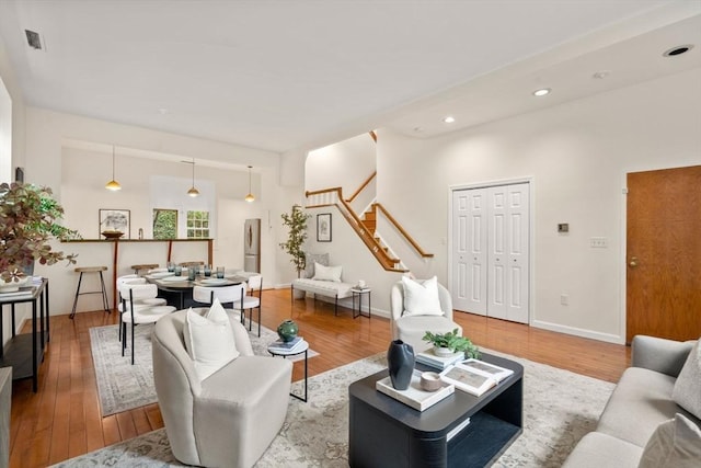living area with stairway, wood finished floors, recessed lighting, and baseboards