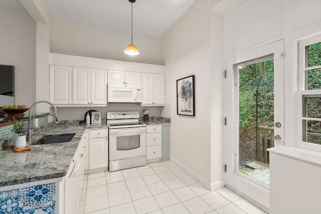 kitchen featuring white appliances, a sink, white cabinetry, light stone countertops, and pendant lighting