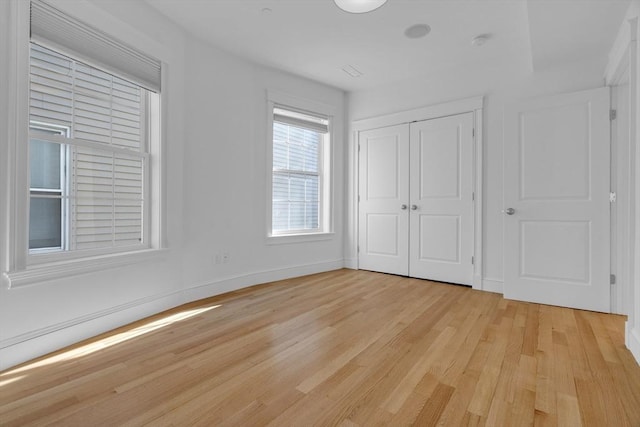 unfurnished bedroom with a closet and light wood-type flooring