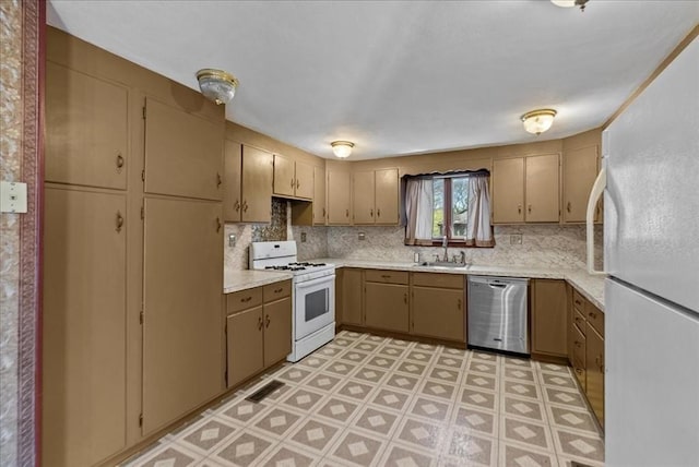 kitchen with light countertops, a sink, white appliances, and tasteful backsplash