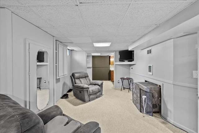 carpeted living area featuring visible vents and a paneled ceiling