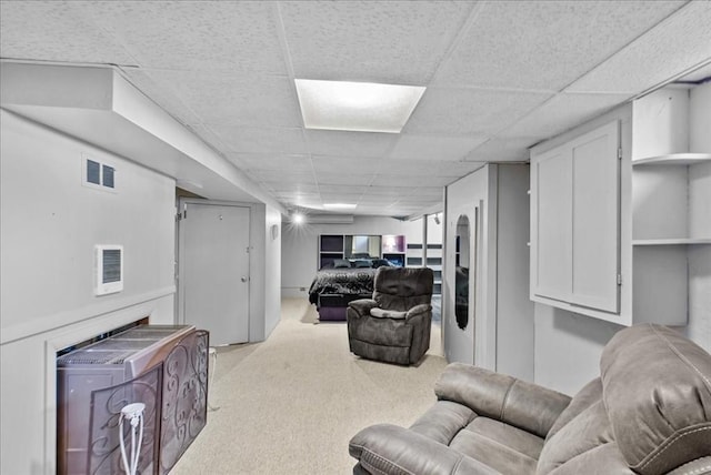carpeted living room featuring visible vents and a paneled ceiling