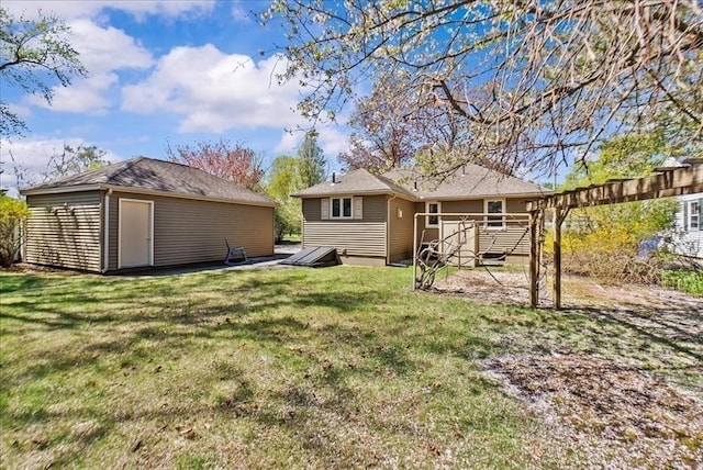 rear view of property featuring an outbuilding, a wooden deck, and a yard