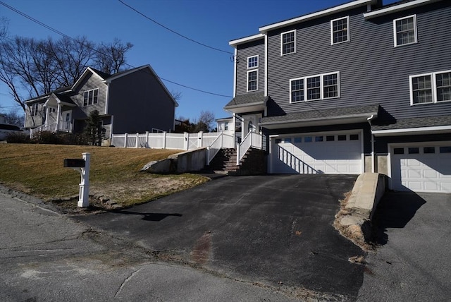 view of property exterior with aphalt driveway, a lawn, a garage, and fence