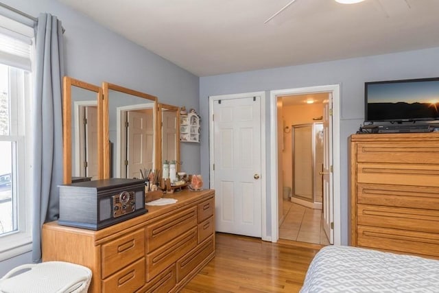 bedroom with light hardwood / wood-style flooring and ensuite bathroom