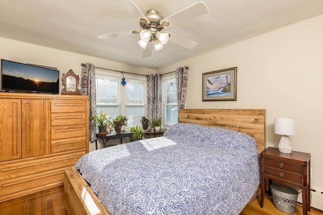 bedroom featuring ceiling fan, wood-type flooring, and baseboard heating