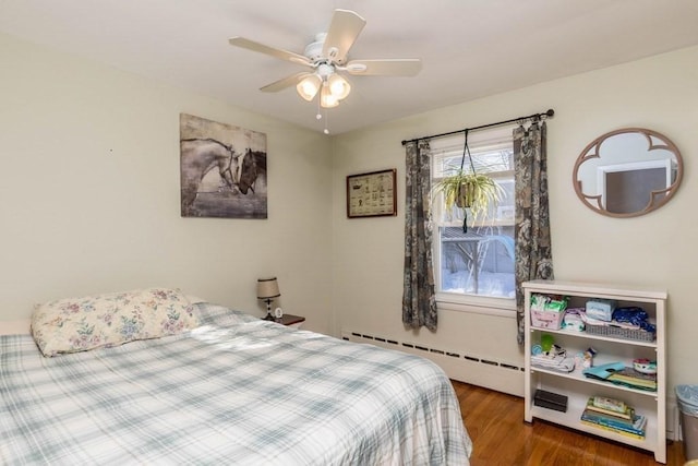 bedroom featuring dark wood-type flooring, a baseboard radiator, and ceiling fan