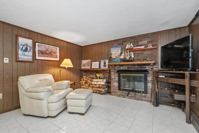 living area with wood walls, a brick fireplace, and light tile patterned floors