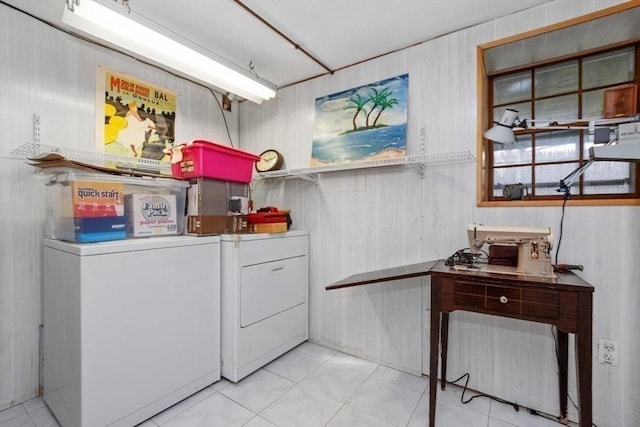 washroom featuring wooden walls, laundry area, washing machine and dryer, and light tile patterned flooring