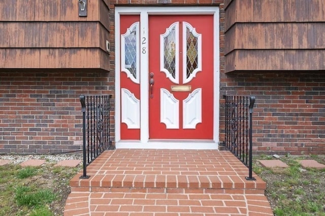 doorway to property with brick siding