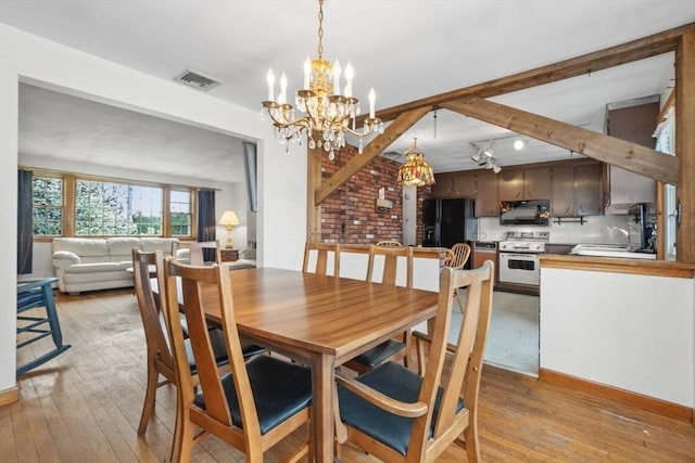 dining space featuring beamed ceiling, visible vents, an inviting chandelier, and light wood-style floors
