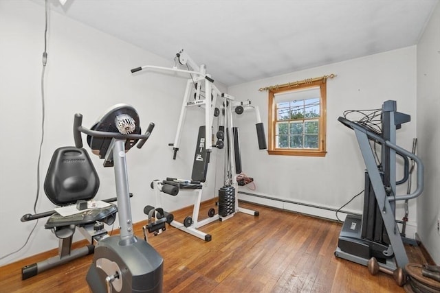 exercise room with baseboard heating and hardwood / wood-style floors