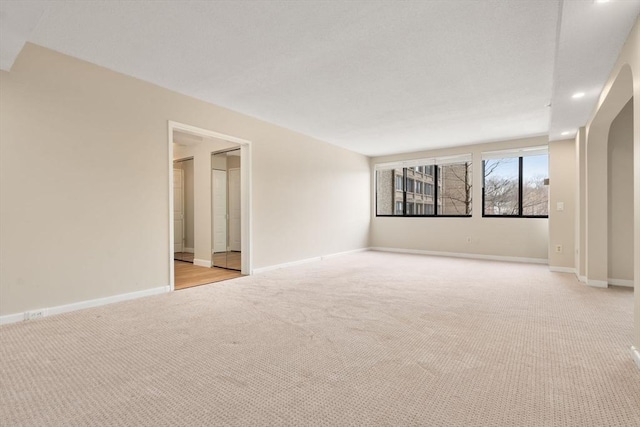 unfurnished room with recessed lighting, baseboards, and light colored carpet