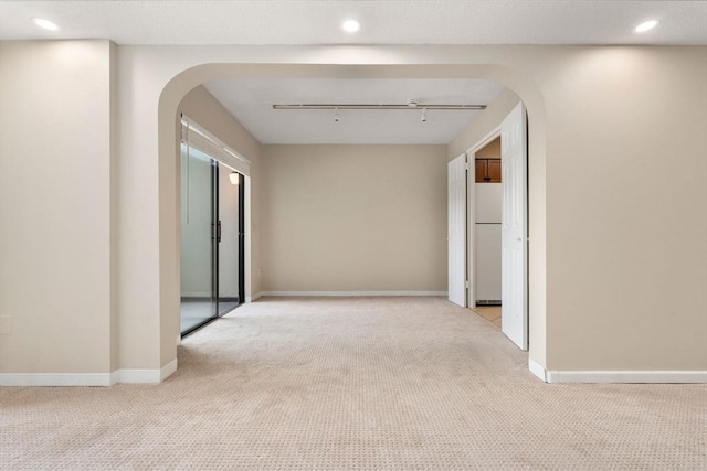 corridor featuring arched walkways, carpet, baseboards, and recessed lighting